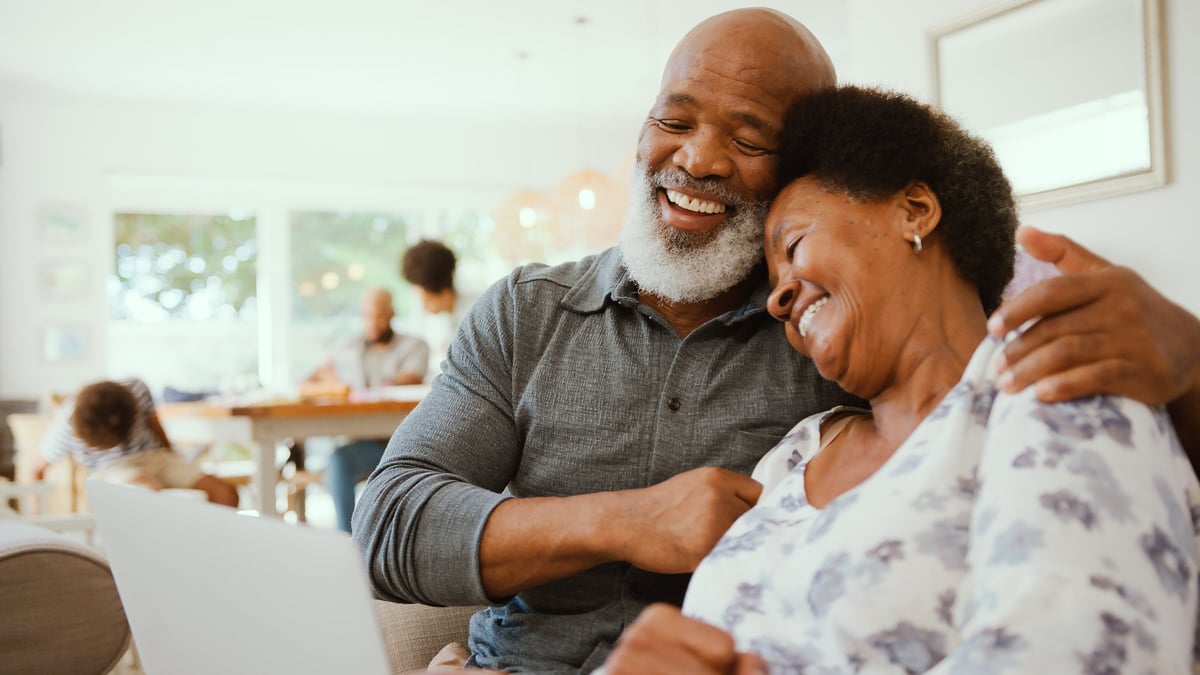 Happy retired couple at home reviewing financial documents together